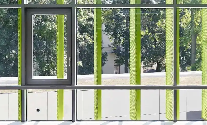 Glasfront mit grünen Läden und dunkel lackierten Kunststofffenstern